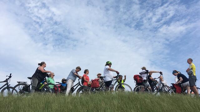 People with bikes standing on a dike. © Cris Toala Olivares.